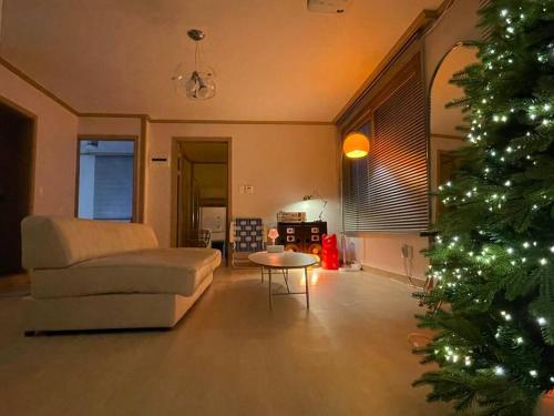 a living room with a couch and a christmas tree at Aufn Orange Bulb in Seoul