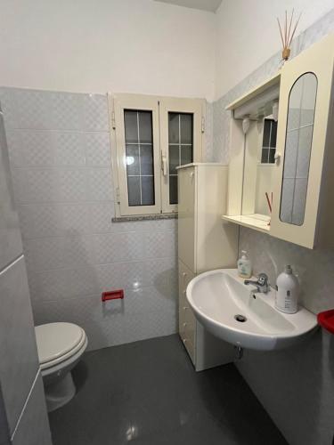 a white bathroom with a toilet and a sink at Casetta Vacanze in Santa Teresa Gallura