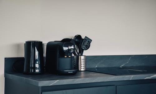 a counter top with a coffee maker and utensils at MarinaPark Residentie Nieuw Loosdrecht in Loosdrecht