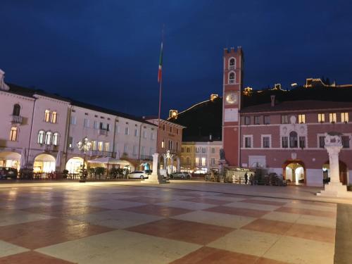 una plaza de la ciudad con una torre de reloj por la noche en Da Alina, en Marostica