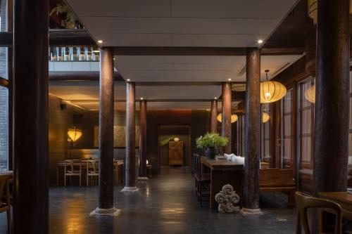 a hallway with tables and chairs in a restaurant at Jing's Residence Pingyao in Pingyao