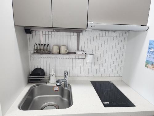 a kitchen sink with white cabinets and a counter top at Sokcho Summitbay 1209 "Ocean View" in Sokcho