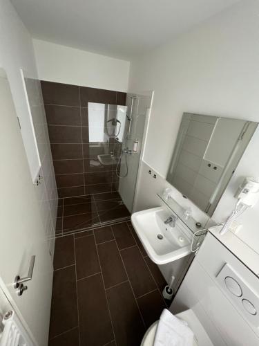 a bathroom with a shower and a sink and a toilet at JJ Hotel Hannover-City-Pension in Hannover