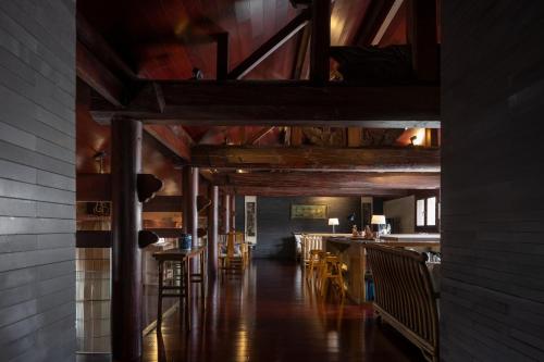 a dining room with wooden ceilings and wooden tables and chairs at Jing's Residence Pingyao in Pingyao