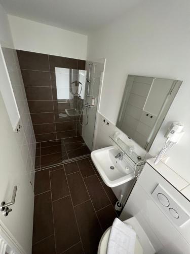 a bathroom with a shower and a toilet and a sink at JJ Hotel Hannover-City-Pension in Hannover