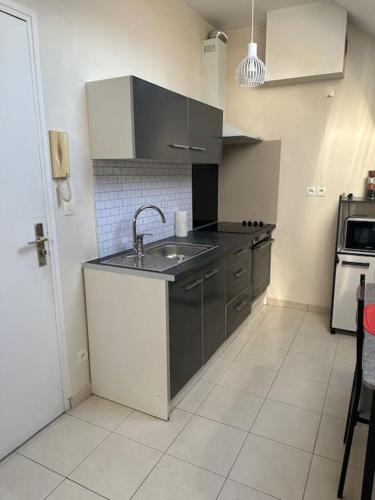une cuisine avec un évier et une cuisinière dans l'établissement Love House 6, à Aulnay-sous-Bois