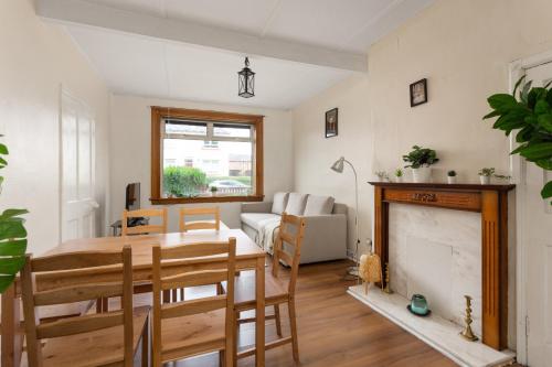 a living room with a table and a fireplace at Stunning 2 bed apartment Free Parking in Edinburgh