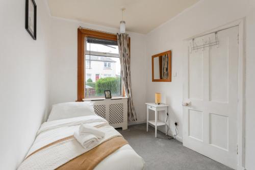 um quarto com 2 camas e uma janela em Stunning 2 bed apartment Free Parking em Edimburgo
