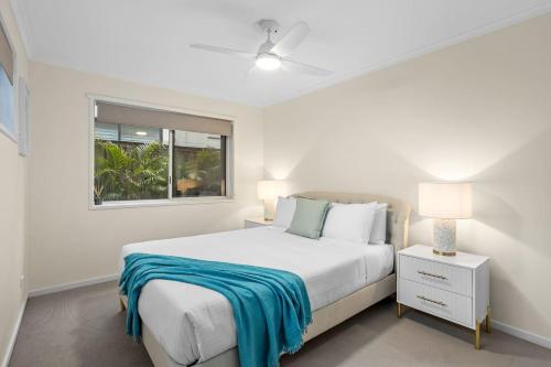 ein weißes Schlafzimmer mit einem Bett und einem Fenster in der Unterkunft Holiday on Hedges - Simple Beachside Comforts in Gold Coast