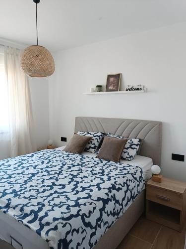 トゥズラにあるZen Apartment Tuzlaのベッドルーム1室(青と白の掛け布団付きのベッド1台付)
