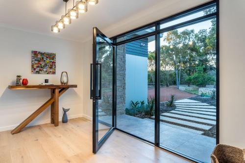 an open pivot door in a home with a desk at It's Five O'Clock Somewhere I Private Properties in Yallingup
