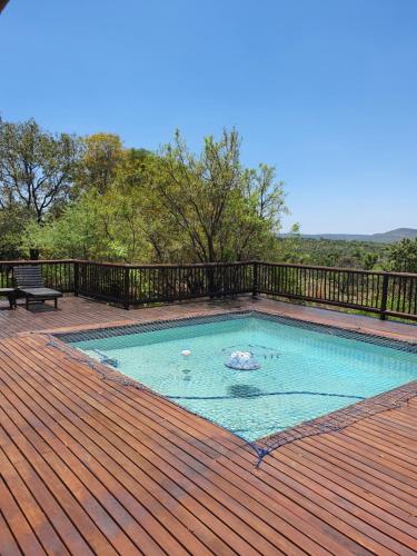 una piscina en una terraza de madera con un banco en Elements Golf Reserve House 303, en Moheme