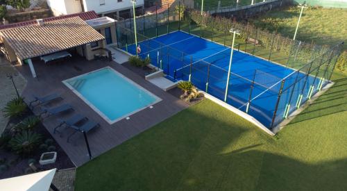 an overhead view of a swimming pool with a tennis court at Casa Grande Gondomil com Campo de Padel, Piscina in Valença