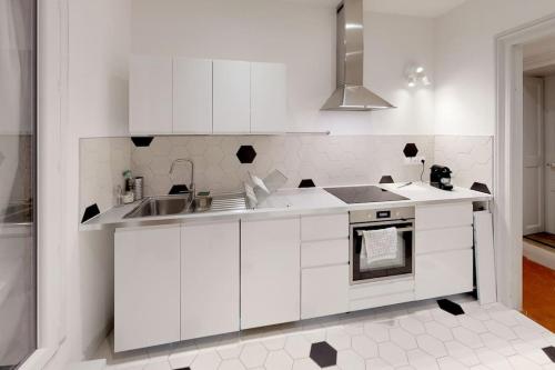 a kitchen with white cabinets and a sink at Mas Saint Côme - Superbe appartement 4 chambres Centre Historique in Montpellier