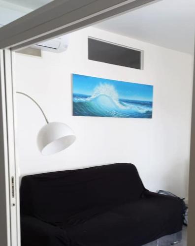 Cette chambre dispose d'un canapé et offre une vue sur l'océan. dans l'établissement Barcarès village - RdC de maison indép. 2/6 p, au Barcarès