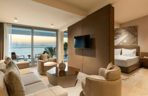 sala de estar con sofá, sillas y TV en Arin Resort Bodrum, en Turgutreis