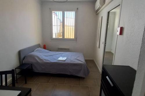 une petite chambre avec un lit et une fenêtre dans l'établissement Barcarès village - RdC de maison indép. 2/6 p, au Barcarès