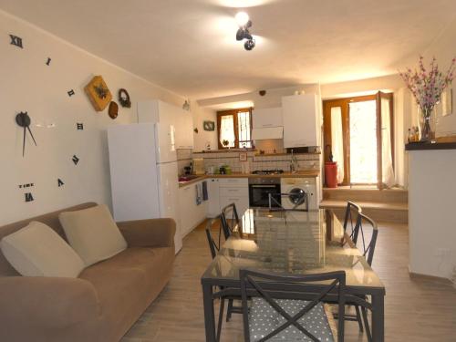 een keuken en een woonkamer met een glazen tafel bij SCAPPO IN UMBRIA, Vicoletto in Porchiano