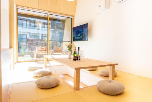 a living room with a wooden table and stools at HAKO REIRO 箱・玲瓏 in Hakone