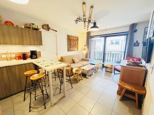 une cuisine et un salon avec une table et des chaises dans l'établissement Appartement central aux Gets avec parking - FR-1-623-258, aux Gets