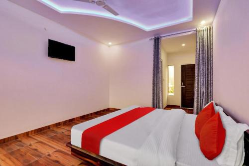 a bedroom with a bed with red pillows at Bala Shankar Resort Kujarwal Group in Haldwāni