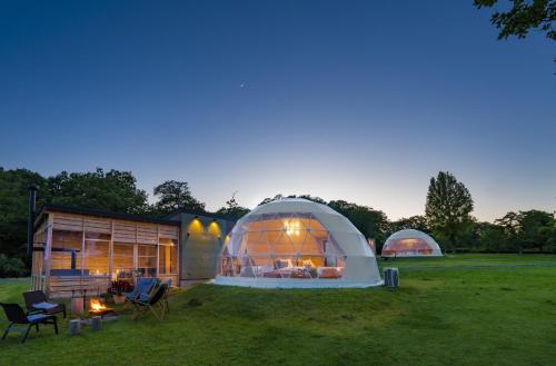 a couple of domes in a field with a house at 備北丘陵公園　湖畔ステイズ庄原 in Shōbara