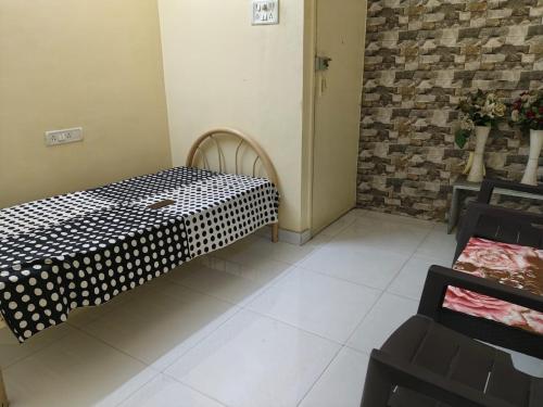 a room with a bed with black and white polka dots at Excelol Home Stay in Thane