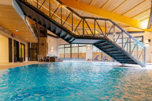 a swimming pool with a staircase in a building at Spa & Wellness Hotel Fitak**** in Liptovský Ján