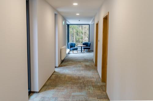 a corridor of an office with chairs and a table at Spa & Wellness Hotel Fitak**** in Liptovský Ján