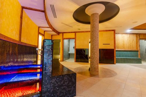 a lobby with a fountain in the middle of a room at Spa & Wellness Hotel Fitak**** in Liptovský Ján