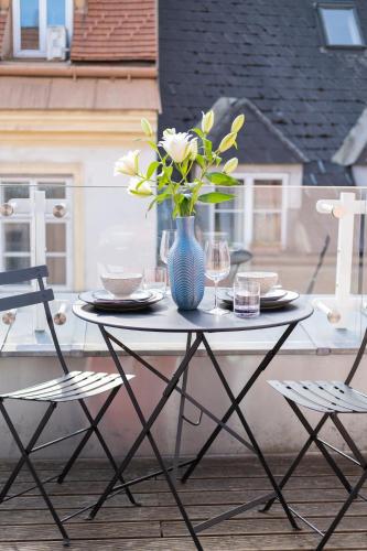 a table with a blue vase with flowers on it at City Stay Vienna – Lugeck in Vienna
