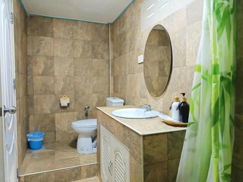 a bathroom with a sink and a toilet and a mirror at Forever Kohmook Bungalows in Koh Mook