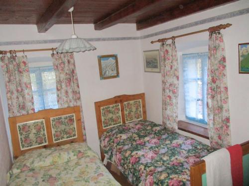 1 dormitorio con 2 camas y 2 ventanas en Pri Mačku, en Tolmin