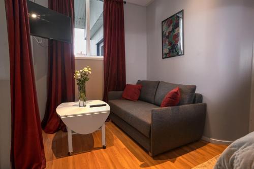 a living room with a couch and a tv at Hotell Ronja in Vimmerby