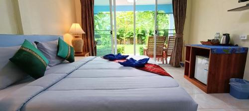 a large bed in a room with a large window at Forever Kohmook Bungalows in Koh Mook