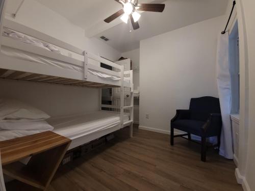 a bedroom with two bunk beds and a chair at One unit of a fully renovated duplex near FSU in Tallahassee