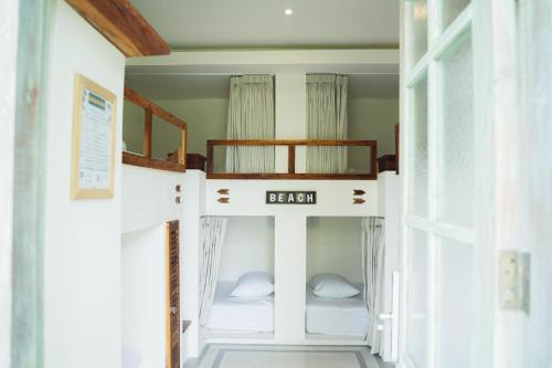 a room with two bunk beds in a house at White Penny Hostel in Seminyak
