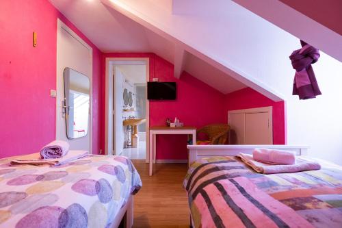 2 camas en una habitación con paredes rosas en Orval16, en Villers-devant-Orval