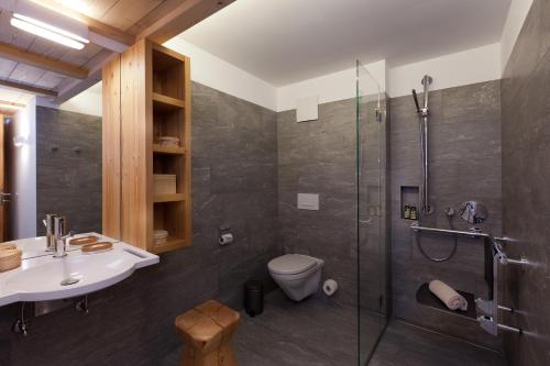 a bathroom with a shower and a toilet and a sink at Chalet Binna in Zermatt