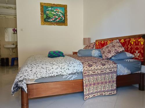 Double N Guesthouse Sanur Bali في سانور: سرير مع لحاف ووسائد عليه
