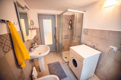 y baño con lavabo y lavadora. en Appartamento - Borgo55 - Centro Paese, en Bosco Chiesanuova