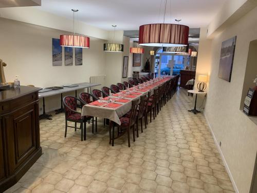 une grande salle à manger avec une grande table et des chaises dans l'établissement Logis Hôtel La Bastide d'Entraigues, à Entraigues-sur-la-Sorgue