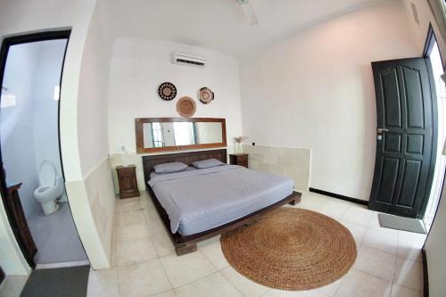 un dormitorio con una cama y un espejo en Jepun Villas 11 - One Bedroom with kitchen, en Uluwatu