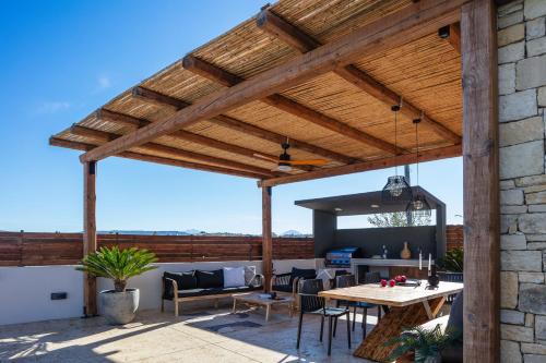 a wooden pavilion with a table and chairs on a patio at Solis Villa, with Heated Pool & 5 minutes to Beach, By ThinkVilla in Kavros