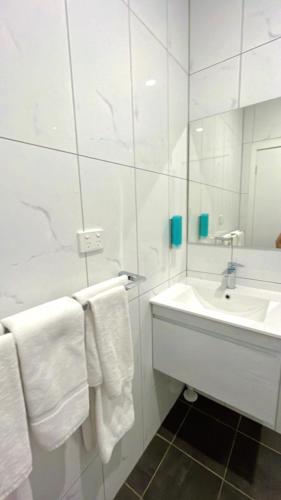 a bathroom with white towels and a sink at Seven Inn in Wagga Wagga