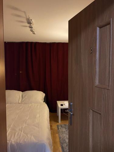 a bedroom with a bed and a red curtain at BEMA Guest House - City Centre in Wrocław