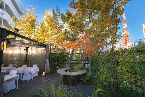 a patio with white tables and a tree and the eiffel tower at Y11 azabu hotel by Mrt in Tokyo