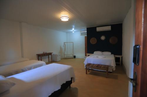 een hotelkamer met 2 bedden en een televisie bij Manoah Trancoso in Trancoso