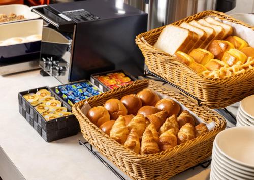 a bakery with baskets of bread and pastries on a counter at ibis Budget Osaka Umeda in Osaka