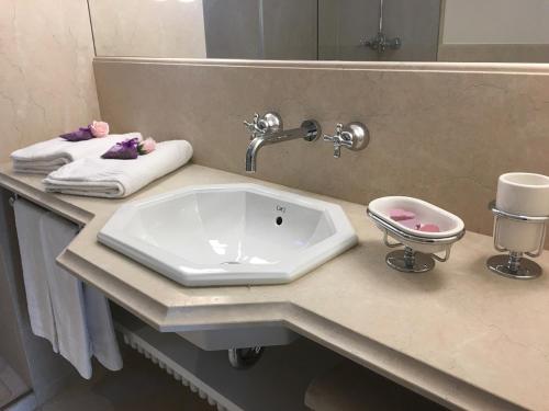 een badkamerbar met een wastafel en een spiegel bij Rambaldi Apartments Casa nr 4 Garden in Bardolino